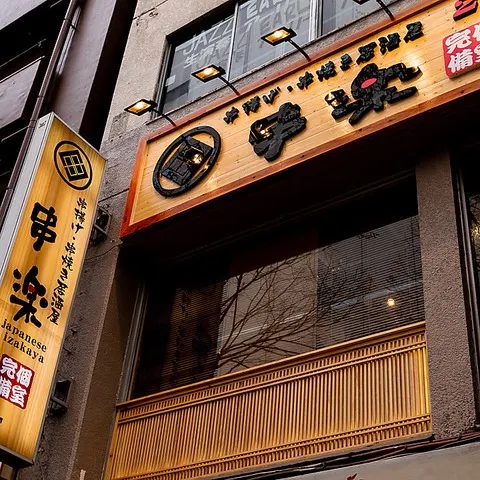 夜の錦糸町に面した建物の二階にある居酒屋の入口付近